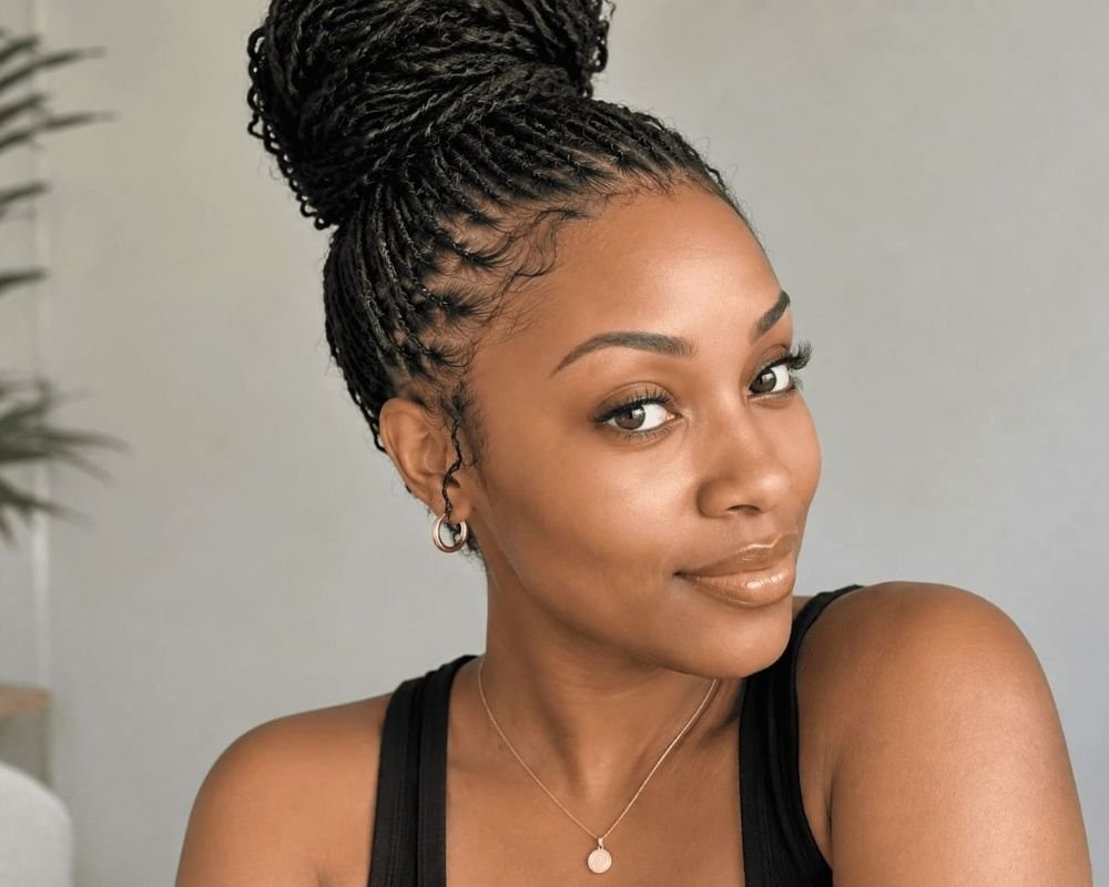 Femme avec des micro locks coiffées en chignon haut