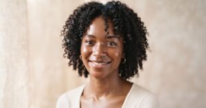 Femme aux cheveux crépus très hydratés et brillants, illustrant une forte porosité bien entretenue